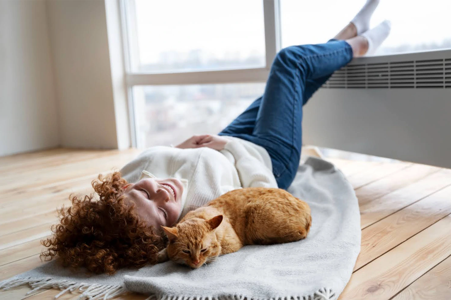 Woman and her cat resting in front of an HVAC unit. Featured image for “What to Do When Your HVAC Unit Freezes in Winter”