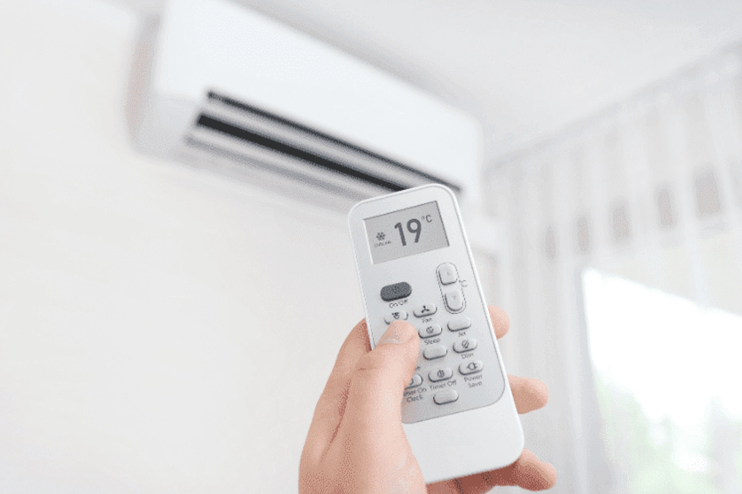An air conditioner with a remote control displaying 19°C, raises the question of how much air conditioning costs per month